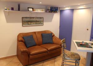 un divano in pelle marrone in soggiorno di Appartamentino Bijou a Torino