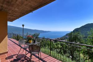 a balcony with a table and chairs and the ocean at Appartamento Le Coste piano terra in Tignale