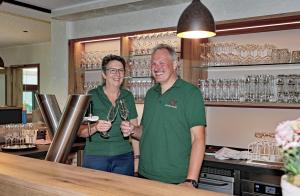 a man and a woman standing at a bar at Hotel zur Post 3 Sterne superior in Altenahr
