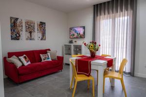 un soggiorno con divano rosso e tavolo di Heaven House a Sant'Egidio del Monte Albino