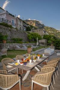 a table and chairs with food on a patio at Villa Marilu Praiano in Praiano