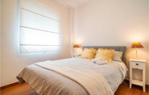 a bedroom with a large white bed with a window at Pet Friendly Apartment in Jerez de la Frontera +5 photos