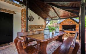 una mesa de madera y sillas en un patio con chimenea en Pet Friendly Home In Hrebinec With Kitchen en Hrebinec