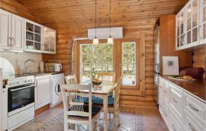 a kitchen with a table and chairs and a window at Holiday Home Blokhus 59 in Blokhus