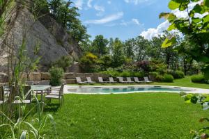 a backyard with a pool and green grass at Villa Torre Delle Rose - Firenzuola, Private Pool, Ac, Privacy in Castelvecchio