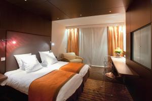a hotel room with a large bed and a television at Hôtel & Spa Vatel in Nîmes