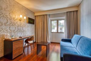 ein Wohnzimmer mit einem blauen Sofa und einem Tisch in der Unterkunft Hotel Lis Batalha in Batalha