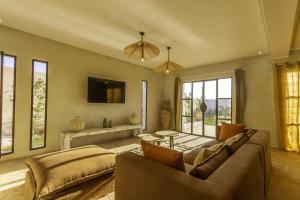 a living room with a couch and a table at Villa Ehzzara piscine chauffée in Essaouira