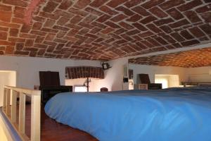 una camera con letto blu e soffitto in mattoni di Appartamentino Bijou a Torino