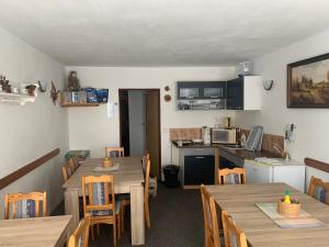 eine Küche und ein Esszimmer mit Holztischen und Stühlen in der Unterkunft Penzion Irena in Strážné