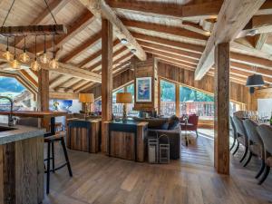 an open living room with wooden ceilings and a dining room at Chalet de luxe familial à Val d'Isère avec spa, proche des pistes et équipements premium - FR-1-567-72 in Val dʼIsère