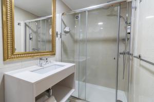 a bathroom with a sink and a glass shower at Hotel Lis Batalha in Batalha