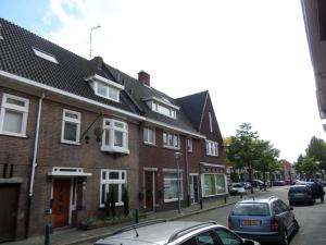 un bâtiment en briques avec des voitures garées dans une rue dans l'établissement Kerkakker2 Modern apartment in the city center, à Eindhoven