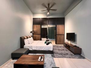 a bedroom with a bed and a flat screen tv at BLUE JADE STUDIOS in Tanah Rata