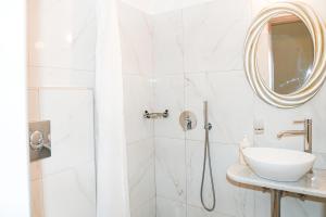 uma casa de banho com um chuveiro, um lavatório e um espelho. em Villa Maina em Kamari