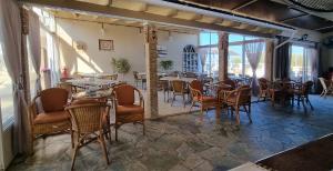 a restaurant with tables and chairs in a room at Bardis Sun studios in Arillas