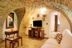 a living room with a couch and a tv at Casafiò Grotta in Cassinasco