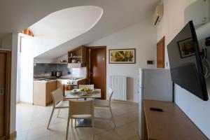 a kitchen and dining room with a table and chairs at Hotel & Apartments Sasso in Diano Marina