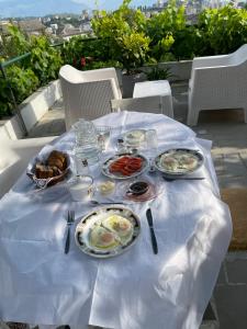 una mesa con platos de comida en un mantel blanco en Guest House Bakuli, en Gjirokastra