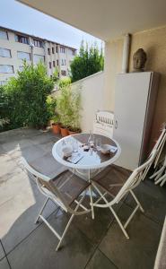 einen weißen Tisch und zwei Stühle auf einer Terrasse in der Unterkunft Charmant studio 2* rdc+ terrasse & parking privé in Aix-les-Bains