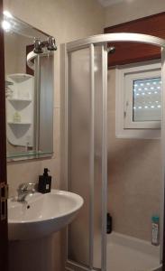 a bathroom with a white sink and a shower at Villa Roxemar en Costa da Morte in A Coruña