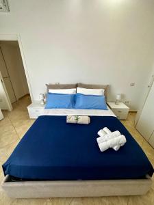 Un dormitorio con una cama azul con toallas. en Casa Bellella, en Torre Annunziata