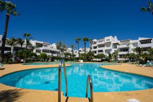 una gran piscina frente a algunos apartamentos en Costalita Beach Apartment, en Estepona