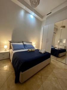 Un dormitorio con una cama grande y un espejo. en Casa Bellella, en Torre Annunziata