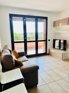 Una sala de estar con un sofá y un televisor. en Solution Home Ripamonti, en Milán