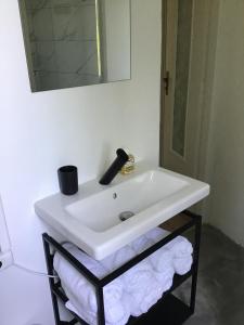 a white sink in a bathroom with towels on a shelf at Casale a la campagne in San Mauro Torinese