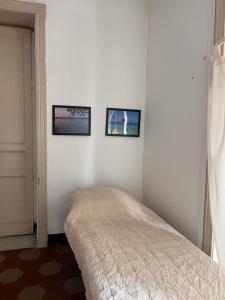 カターニアにあるCentro storico cataniaの壁に2枚の写真が飾られたベッドルーム1室、ベッド1台が備わります。