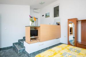 een woonkamer met een tv en een bed bij Apartmani Frka in Sali