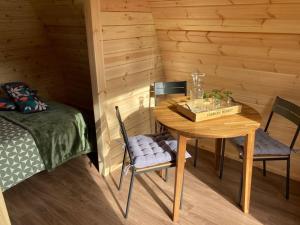 a wooden room with a table and chairs and a bed at POD Découverte logement suédois in Chazelles