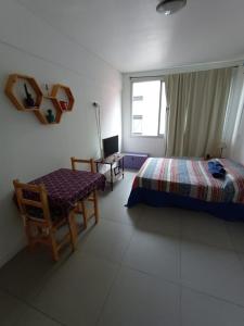 sypialnia z łóżkiem, krzesłem i biurkiem w obiekcie Departamento con pileta Almagro w BuenosAires