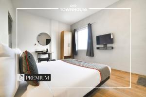 a hotel room with a bed and a tv at Super Townhouse Boutique Hotel 242 Sarjapur Road in Bangalore