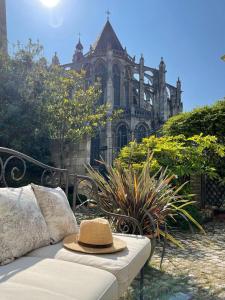 un sombrero sentado en un sofá frente a un edificio en LA MAISON CANONIALE luxe et charme au coeur de Tours, en Tours