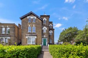 an old brick building with a green door at The Earl - Hampstead Heath in London