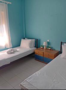 two beds in a room with a blue wall at By the sea dome in Maronia