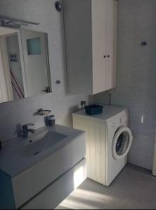 a bathroom with a washing machine and a sink at By the sea dome in Maronia