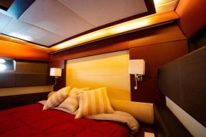 een slaapkamer met een rood bed met 2 kussens bij A bordo della Maeva Star in Palermo