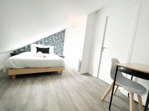 um quarto com uma cama, uma mesa e uma secretária em T4 Pamplemousse Cosy proche plages et commerces em Saint-Nazaire