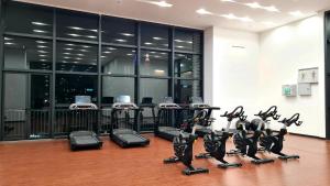 a gym with a row of treadmills and exercise bikes at Chambers Serviced Suites KLCC by Cozy Stay in Kuala Lumpur