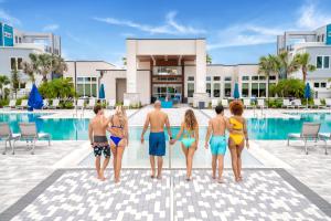 a group of people standing by the pool at a resort at Lovely Condo near Disney w Hotel Amenities - 7770-26-210 in Kissimmee