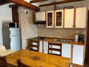 cocina con mesa, fregadero y nevera en Apartment Anamarija, en Poreč