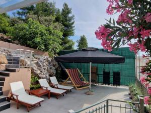 - un ensemble de chaises et d'un parasol sur la terrasse dans l'établissement Kuća za odmor Teja, à Trogir