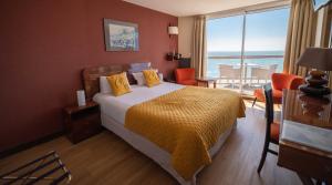 a hotel room with a bed and a large window at LOGIS HOTEL - La Petite Rade in Le Havre +37 photos