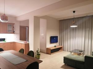 a living room with a dining table and a kitchen at Feather Apartments-Nea Moudania Halkidiki in Nea Moudania