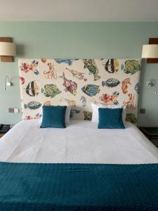 a bedroom with a large bed with blue pillows at LOGIS HOTEL - La Petite Rade in Le Havre