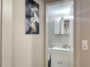 a bathroom with a white sink and a mirror at Aiginetan Apartments in Egina