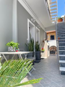 a patio with a table and potted plants on it at Aiginetan Apartments in Aegina Town